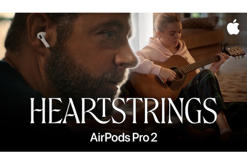 Screenshot from Apple's Heartstrings ad showing man with AirPods and woman playing the guitar