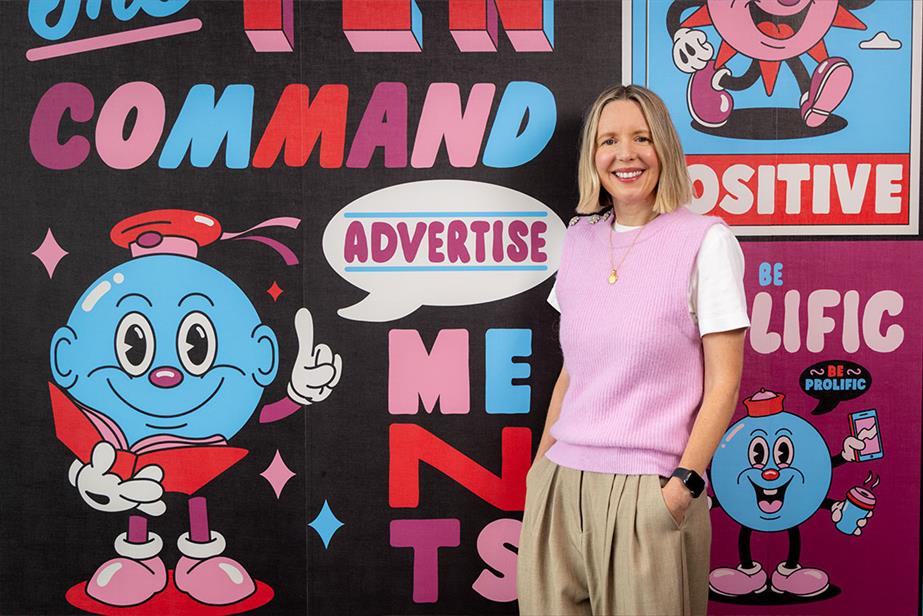 Portrait of Helen Rhodes in front of a wall with the ten commandments of advertisements