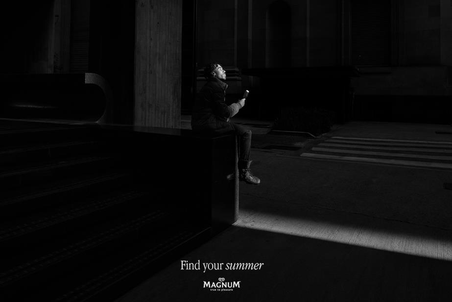 Person sat in ray of sunlight eating ice cream in winter