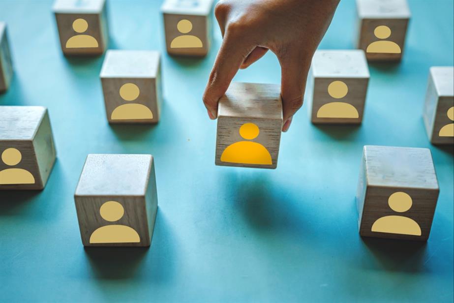 Hand picking up a block with image of person on it