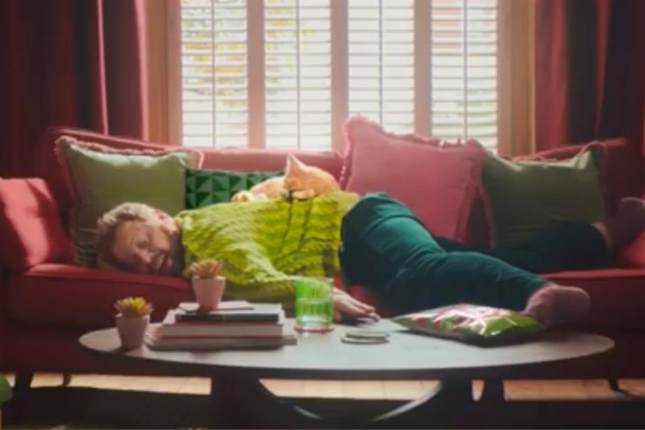 Man lying on sofa with cat on his back