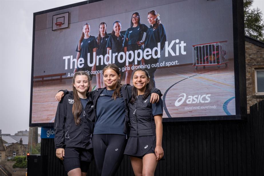 Three girls standing in front of a billboard