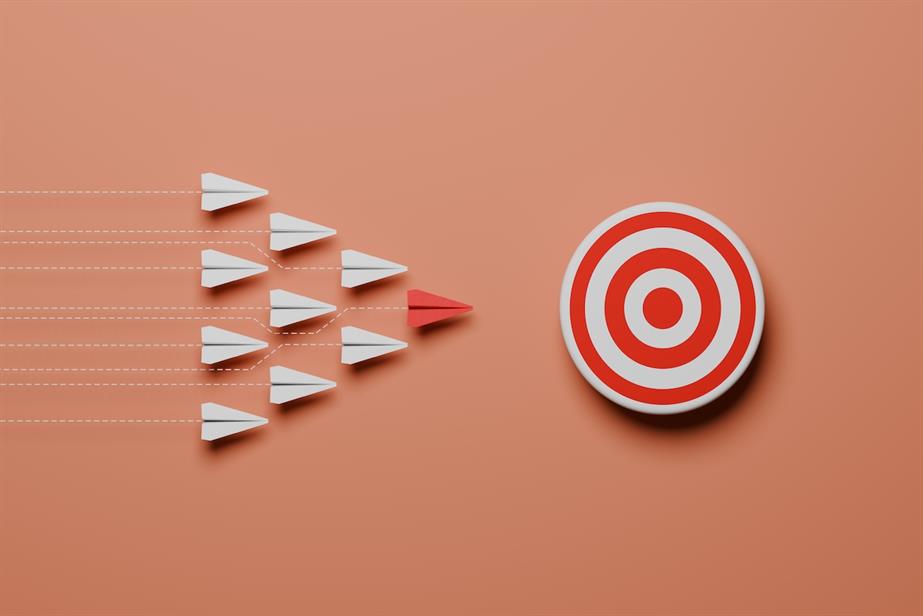 Target board with darts travelling towards it